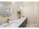 Modern bathroom featuring double vanity with brass fixtures and tiled walk-in shower at 15115 Rocky Bluff Loop, Davidson, NC 28036