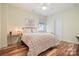 Cozy bedroom featuring hardwood floors, a ceiling fan, and soft, inviting bedding at 15115 Rocky Bluff Loop, Davidson, NC 28036