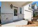 Welcoming front porch with decorative wreath, exposed brick, and seating at 15115 Rocky Bluff Loop, Davidson, NC 28036