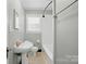 Cozy bathroom with a shower over tub, window, and black and white tile floor at 1631 Fulton Ave, Charlotte, NC 28205