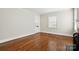 Bright living room featuring hardwood floors, natural light from the window, and entry door at 1631 Fulton Ave, Charlotte, NC 28205