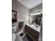 Bathroom with dual sinks, large framed mirror, vanity storage, neutral paint, and ceramic tile at 18224 Taffrail Way, Cornelius, NC 28031