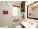 Bright bathroom with white tiled walls, vanity sink, medicine cabinet, and a window for natural light and ventilation at 1900 Union St, Charlotte, NC 28205
