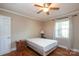 Cozy bedroom featuring wood floors, a ceiling fan, and a bright window with curtains for natural light and comfort at 1900 Union St, Charlotte, NC 28205