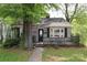 View of home with gray brick, dark shutters, and a small porch visible from the sidewalk at 1900 Union St, Charlotte, NC 28205