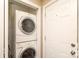 Efficient laundry area with stacked washer and dryer unit and a white door, maximizing space and functionality at 1900 Union St, Charlotte, NC 28205