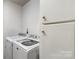 Laundry area with white washer and dryer units, complemented by a matching storage cabinet at 1923 Tracy Ct, Fort Mill, SC 29708
