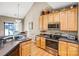 Bright kitchen with light wood cabinets, stainless appliances, and hardwood floors provides ample counterspace at 2014 Arbor Crest Ct, Charlotte, NC 28262