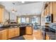 Bright kitchen with wood cabinets, stainless appliances, and hardwood floors offers seamless dining room access at 2014 Arbor Crest Ct, Charlotte, NC 28262