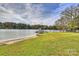 Expansive grassy backyard leading to a tranquil lake with a covered boat dock, ideal for waterside enjoyment at 2045 Driftwood Cir, Fort Mill, SC 29708