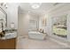 Elegant bathroom featuring a soaking tub, granite countertop vanity, and a large window at 2045 Driftwood Cir, Fort Mill, SC 29708