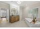 Elegant bathroom featuring a soaking tub, granite countertop vanity, and a large window at 2045 Driftwood Cir, Fort Mill, SC 29708