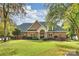 A stunning two-story brick home boasts a meticulously landscaped front yard, with mature trees and a well-manicured lawn at 2045 Driftwood Cir, Fort Mill, SC 29708