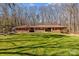 Charming ranch-style home featuring brick facade, red shutters, a well-maintained lawn, and a lush tree-lined backdrop at 220 Gregory Rd, Salisbury, NC 28147
