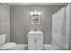 A clean bathroom features modern fixtures, a toilet, and a shower with a floral shower curtain at 2301 Shamrock Dr, Charlotte, NC 28205