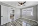 Bedroom with gray walls, ceiling fan, hardwood floors, and abundant natural light at 2301 Shamrock Dr, Charlotte, NC 28205