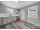 Modern kitchen with gray cabinets, stainless steel appliances, and a bright window overlooking the backyard at 2301 Shamrock Dr, Charlotte, NC 28205