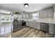 Kitchen featuring modern stainless appliances, gray cabinets, and hardwood floors at 2301 Shamrock Dr, Charlotte, NC 28205
