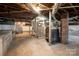 Spacious unfinished basement with exposed ductwork, wooden stairs, and concrete floors at 260 Penninger Dr, Woodleaf, NC 27054