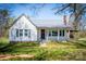 Charming one-story home featuring white siding, a metal roof, and a welcoming front porch at 260 Penninger Dr, Woodleaf, NC 27054