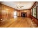 Traditional living room boasts wood paneling, hardwood floors, fireplace, and an open doorway at 260 Penninger Dr, Woodleaf, NC 27054