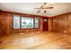 Traditional living room showcasing wood paneling, hardwood floors, ceiling fan, and natural light at 260 Penninger Dr, Woodleaf, NC 27054