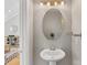 Charming powder room features a pedestal sink, oval mirror, and modern lighting fixture above sink at 2709 Yadkin Ave, Charlotte, NC 28205