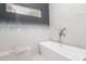 Contemporary bathroom featuring a soaking tub, decorative tile, and a window for natural light at 3119 Knowlton Ln, Charlotte, NC 28205
