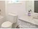 Clean bathroom featuring a toilet, vanity with white countertop, and a tiled wall at 3119 Knowlton Ln, Charlotte, NC 28205