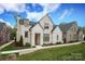 Charming white brick home featuring a manicured lawn, lush landscaping, and inviting entry at 3119 Knowlton Ln, Charlotte, NC 28205