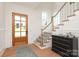 Elegant foyer with hardwood floors, staircase with white railings and traditional-style door at 3119 Knowlton Ln, Charlotte, NC 28205