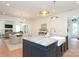 Open kitchen with large island, marble countertops, pendant lights and view to the living room at 3119 Knowlton Ln, Charlotte, NC 28205