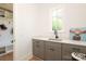 Mudroom sink with gray shaker cabinets next to built in cubbies and bench at 3119 Knowlton Ln, Charlotte, NC 28205