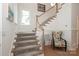 Elegant staircase featuring wood handrail, plush carpet, and decorative chair at 3119 Knowlton Ln, Charlotte, NC 28205