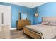 Cozy bedroom featuring a natural wood dresser, a guitar on the wall, and light hardwood floors at 320 Allspice Rd, Fort Mill, SC 29708