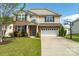 Charming two-story home featuring a well-maintained lawn, two-car garage, and classic brick and siding exterior at 320 Allspice Rd, Fort Mill, SC 29708