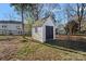 Storage shed in a large backyard with lawn. Includes access to a wooden fence and foliage at 3217 Deep Meadow Ln, Charlotte, NC 28210