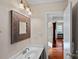 Well-lit half bathroom with a decorative mirror, vanity sink, and neutral color scheme at 3217 Deep Meadow Ln, Charlotte, NC 28210