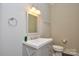A bathroom with a white sink vanity, a toilet, decorative mirror and a towel rack on light neutral walls at 341 Canvasback Rd, Mooresville, NC 28117