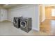The laundry room features two modern grey washing machines, a door, and wire shelving at 341 Canvasback Rd, Mooresville, NC 28117