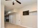 A living room with a ceiling fan, TV, and a doorway to the laundry room with modern grey washing machines at 341 Canvasback Rd, Mooresville, NC 28117