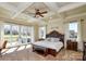 Luxurious main bedroom with tray ceilings, a plush bed, and access to a private balcony at 341 Canvasback Rd, Mooresville, NC 28117