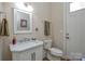 Charming powder room featuring a white vanity with marble countertop and a decorative mirror at 341 Canvasback Rd, Mooresville, NC 28117