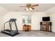 Finished bonus room with a ceiling fan, carpeted floors, a treadmill, and TV at 3905 Farlow Rd, Charlotte, NC 28269