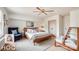A brightly lit primary bedroom with hardwood frame bed, wing chair, and stylish furnishings at 3905 Farlow Rd, Charlotte, NC 28269