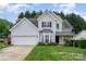 Beautiful two-story home with grey siding, lush green lawn, and an attached two-car garage at 3905 Farlow Rd, Charlotte, NC 28269