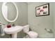 Tastefully decorated powder room with a pedestal sink, toilet, and framed artwork at 3905 Farlow Rd, Charlotte, NC 28269