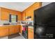 Galley kitchen with matching wooden cabinets and black appliances, ample counterspace at 410 E Lee Ave, Bessemer City, NC 28016