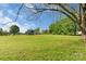 Expansive green backyard with a serene and spacious lawn, complimented by mature trees and distant houses at 421 Tranquil Bay Cir, Norwood, NC 28128