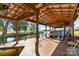 Spacious boat dock with a covered area, featuring wooden decking, boat lift, and tranquil waterfront views at 421 Tranquil Bay Cir, Norwood, NC 28128